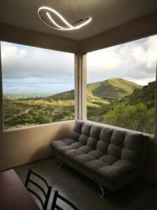 Sala de estar de Potrero del Rey con ventanales y vista a las sierras de Estancia Grande
